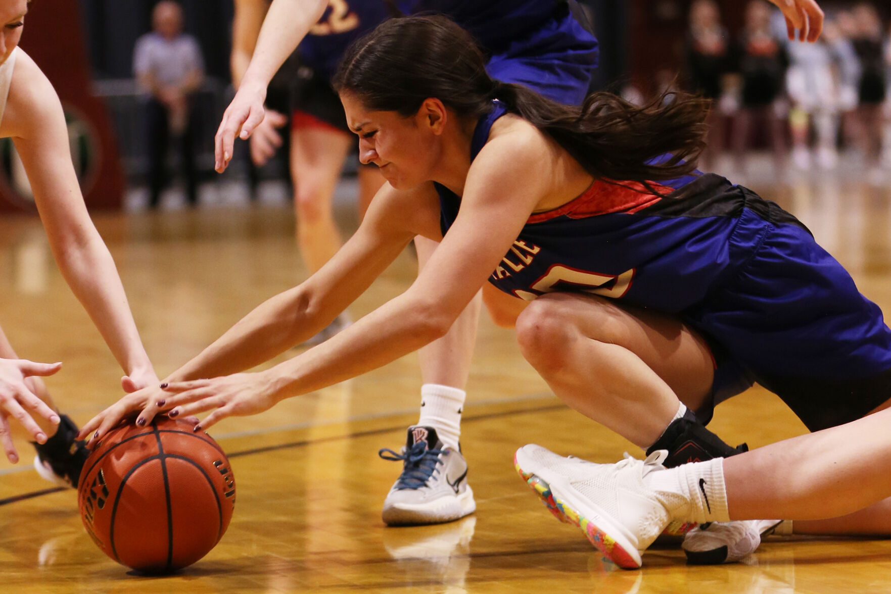 Jackie Ramirez dives to steal a ball away from a Burlington player